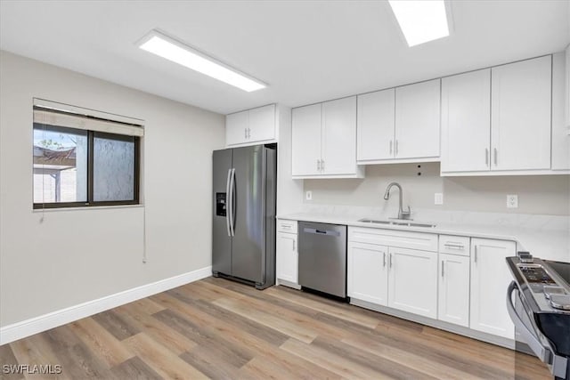 kitchen featuring sink, light hardwood / wood-style flooring, stainless steel appliances, and white cabinets