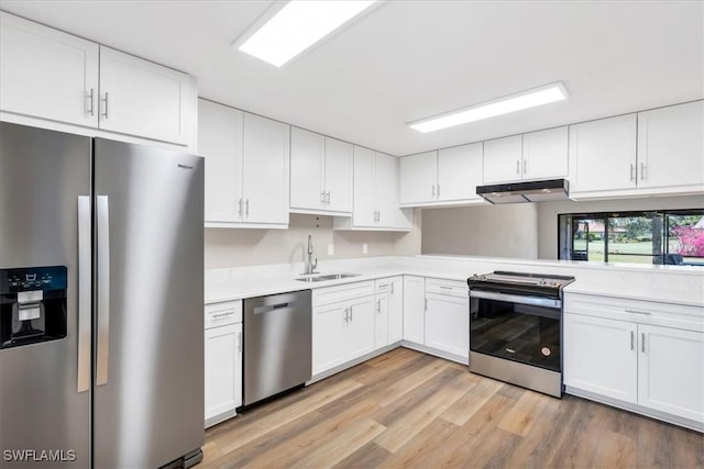 kitchen with stainless steel appliances, white cabinetry, and sink