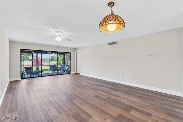 unfurnished room featuring hardwood / wood-style flooring, ceiling fan, and a textured ceiling