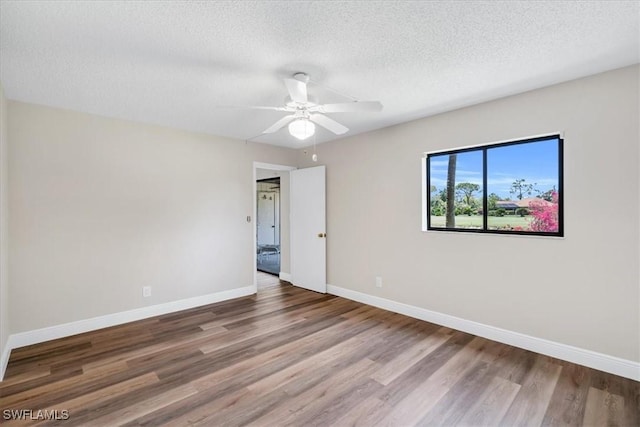 spare room with ceiling fan, wood-type flooring, and a textured ceiling