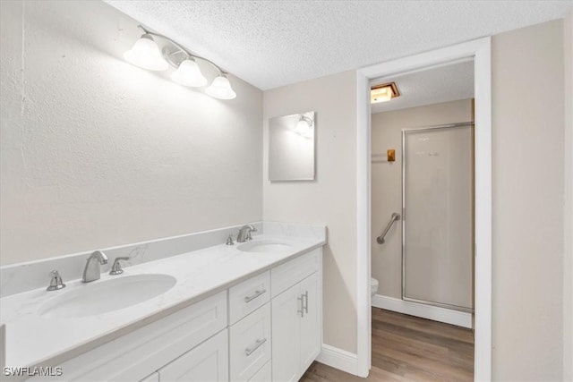 bathroom featuring vanity, an enclosed shower, and a textured ceiling