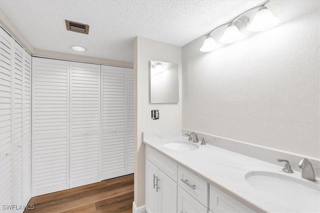 bathroom with vanity, wood-type flooring, and a textured ceiling