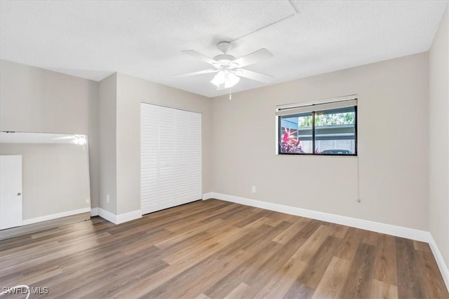 empty room with hardwood / wood-style flooring, ceiling fan, and a textured ceiling