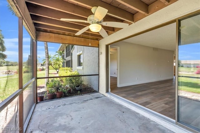 unfurnished sunroom featuring ceiling fan