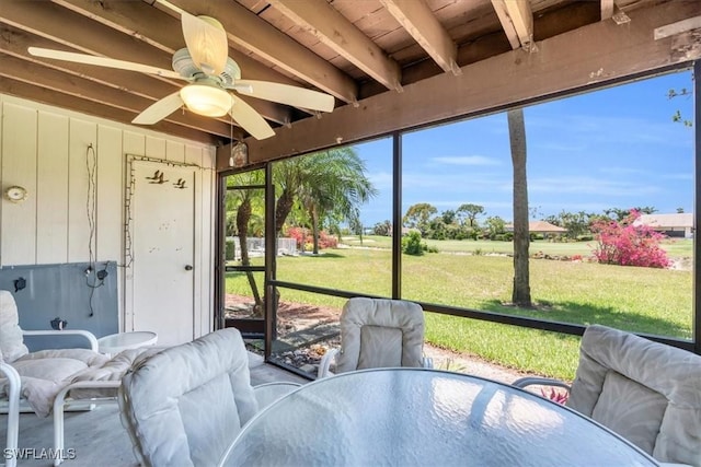 sunroom featuring ceiling fan and beamed ceiling