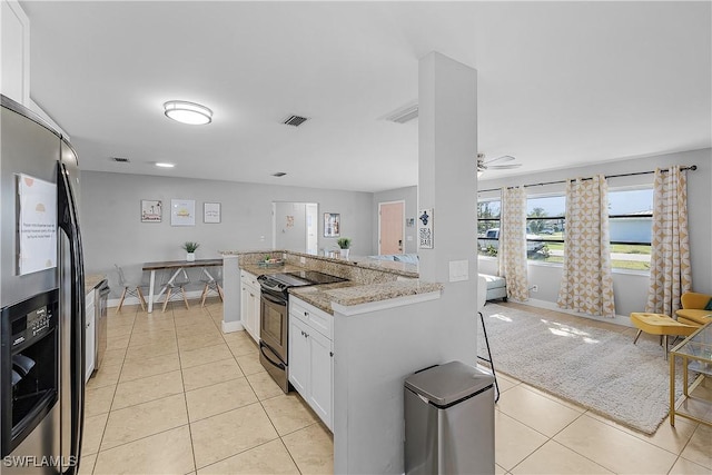 kitchen featuring light tile patterned flooring, light stone counters, white cabinetry, appliances with stainless steel finishes, and ceiling fan