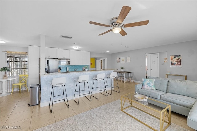 tiled living room featuring ceiling fan