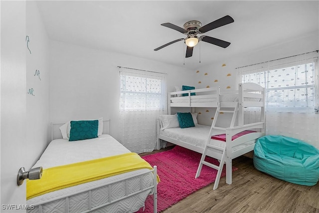 bedroom with multiple windows, hardwood / wood-style floors, and ceiling fan