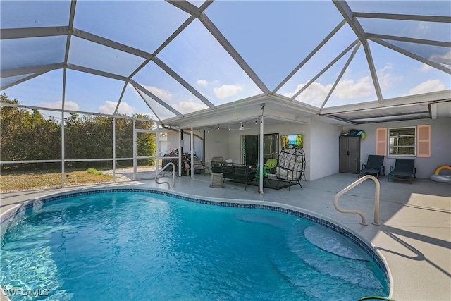 view of pool with a patio area and glass enclosure