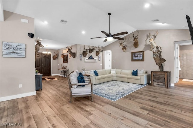 living room with light hardwood / wood-style flooring, ceiling fan, and vaulted ceiling