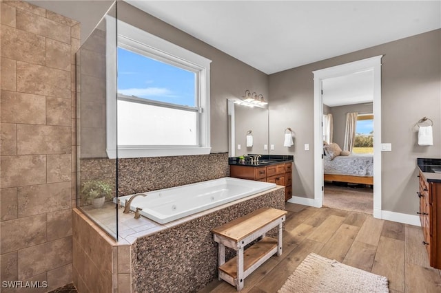 bathroom featuring vanity, tiled bath, and hardwood / wood-style floors