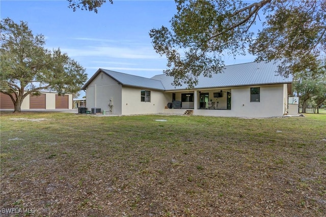 back of house with cooling unit and a yard