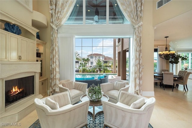 interior space with ornamental molding, a towering ceiling, and a notable chandelier