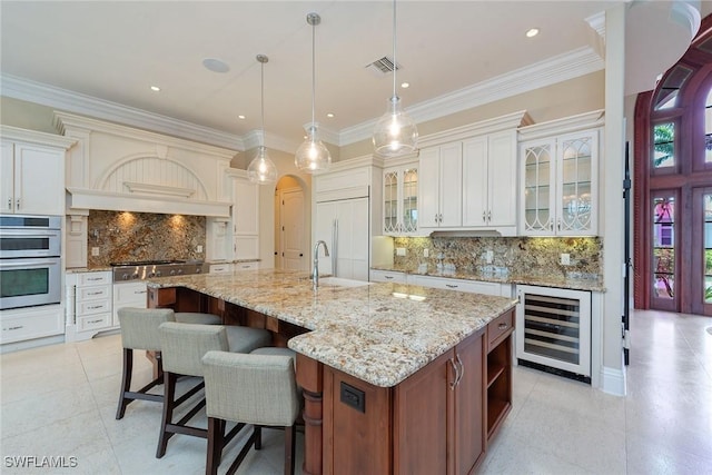 kitchen with wine cooler, pendant lighting, stainless steel appliances, a large island, and white cabinets