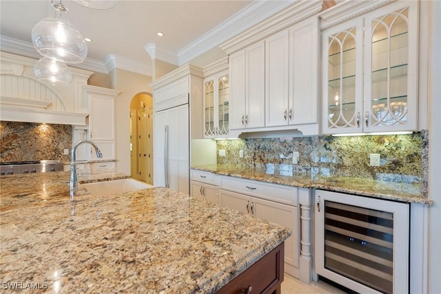 kitchen featuring decorative light fixtures, sink, white cabinets, wine cooler, and crown molding