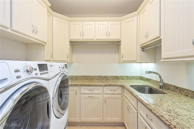 washroom featuring cabinets, independent washer and dryer, and sink