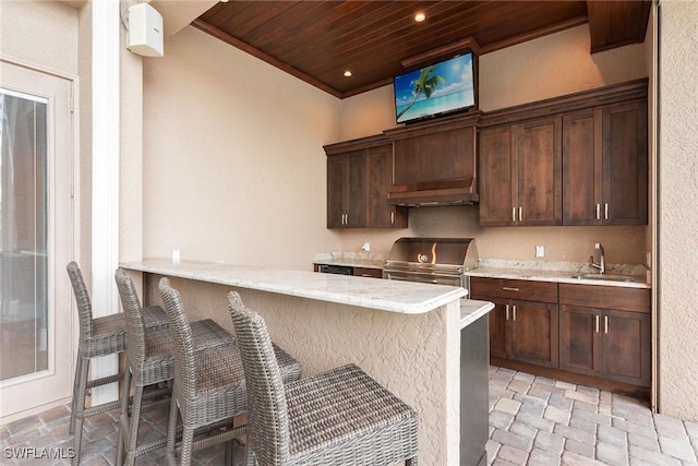 kitchen with sink, wooden ceiling, a breakfast bar, and kitchen peninsula