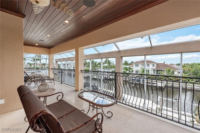 sunroom with wooden ceiling and a water view