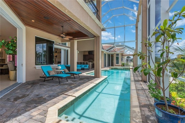 view of swimming pool featuring a patio, a lanai, an outdoor hangout area, and ceiling fan