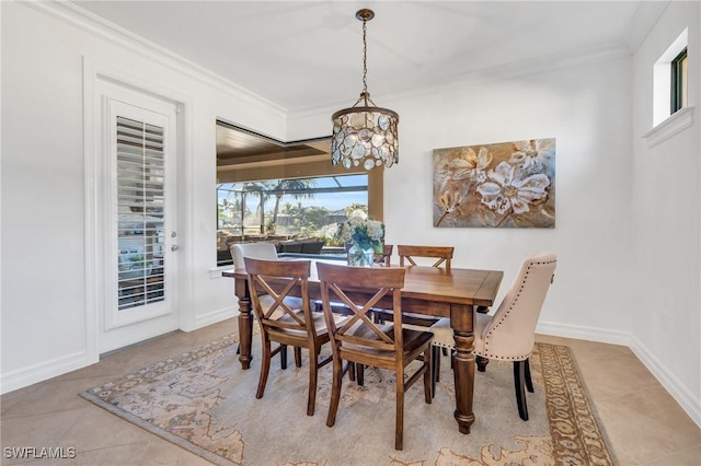 tiled dining area featuring crown molding and a notable chandelier