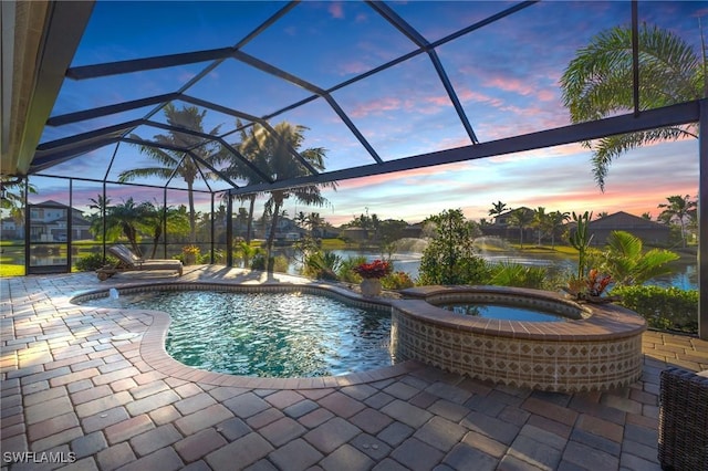 pool at dusk featuring an in ground hot tub, a water view, a lanai, and a patio