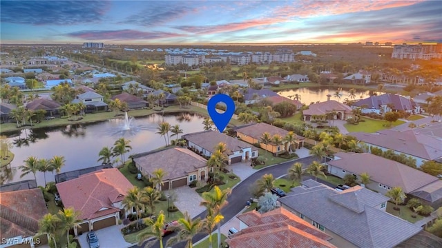 aerial view at dusk featuring a water view