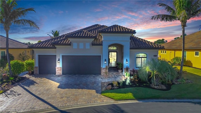 mediterranean / spanish house featuring a garage and a yard