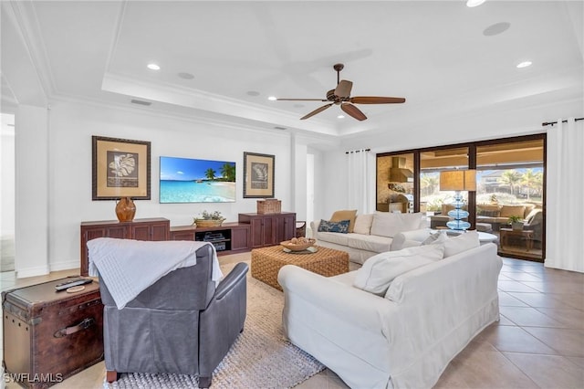 tiled living room featuring ceiling fan, ornamental molding, and a raised ceiling