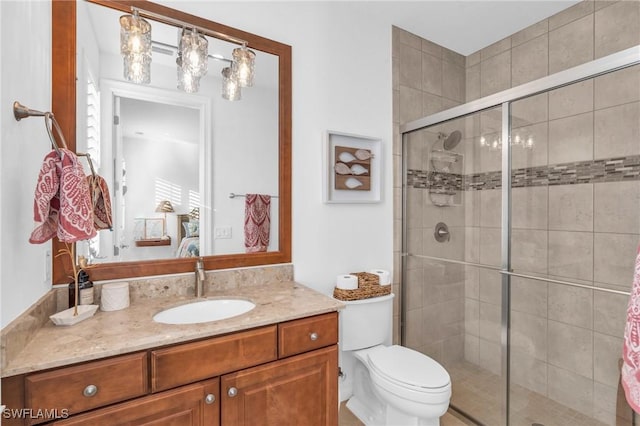 bathroom featuring walk in shower, vanity, and toilet