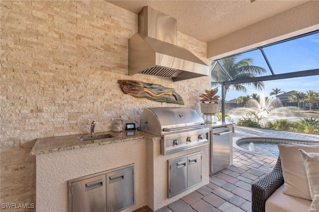 view of patio with sink, a lanai, grilling area, and exterior kitchen