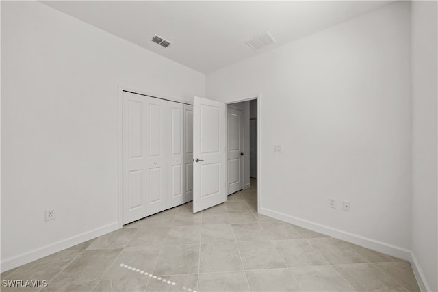 unfurnished bedroom with a closet and light tile patterned floors