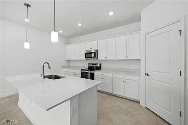 kitchen with sink, appliances with stainless steel finishes, a kitchen island with sink, white cabinetry, and hanging light fixtures