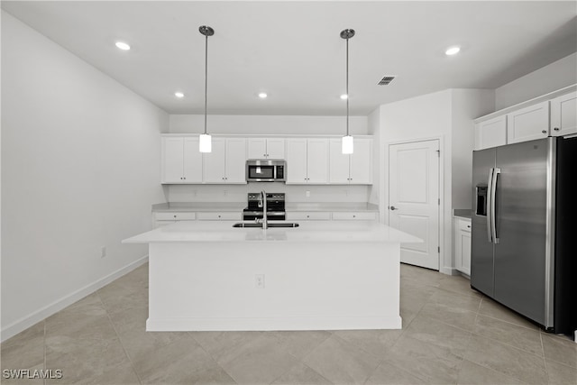 kitchen with white cabinetry, stainless steel appliances, hanging light fixtures, and a center island with sink