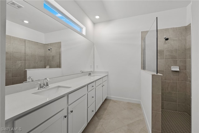 bathroom with vanity, tiled shower, and tile patterned floors