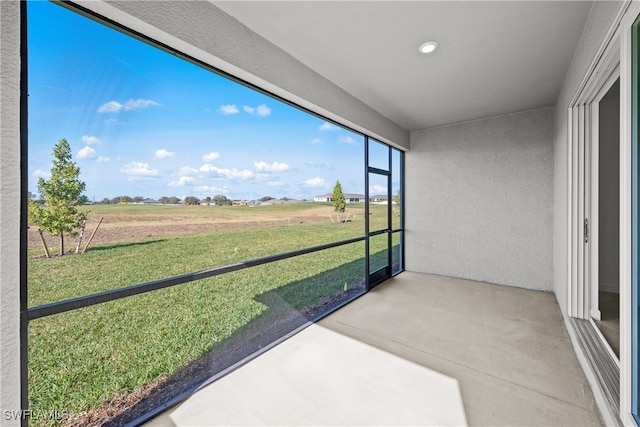 unfurnished sunroom with a rural view