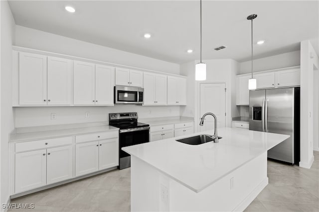 kitchen with sink, white cabinetry, hanging light fixtures, stainless steel appliances, and an island with sink