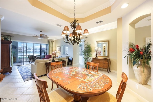 tiled dining room featuring crown molding, a raised ceiling, and ceiling fan with notable chandelier