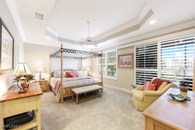 bedroom with crown molding, light carpet, ceiling fan, and a tray ceiling