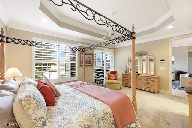 carpeted bedroom with crown molding and a tray ceiling