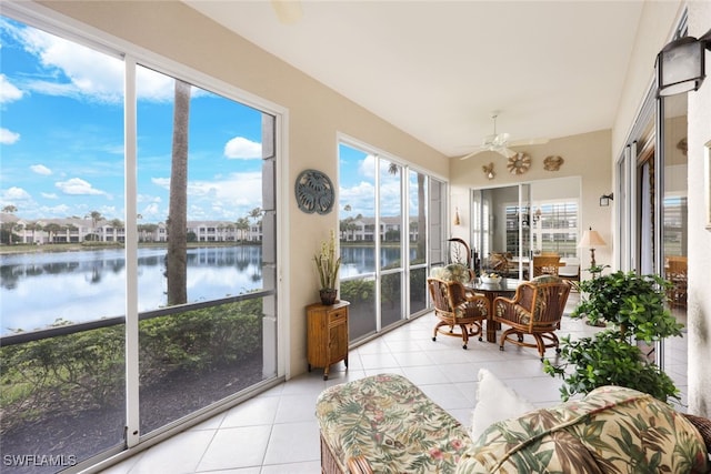 sunroom / solarium with ceiling fan and a water view