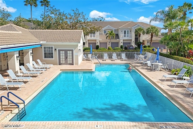 view of pool with french doors and a patio