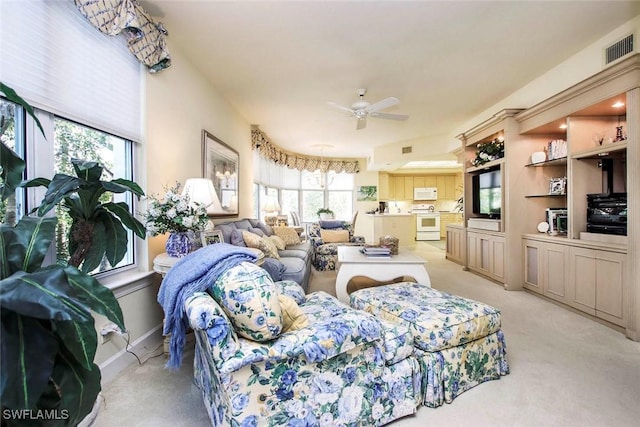 carpeted living room with ceiling fan