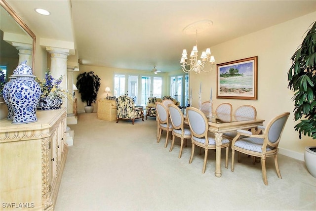 carpeted dining space with a chandelier and ornate columns