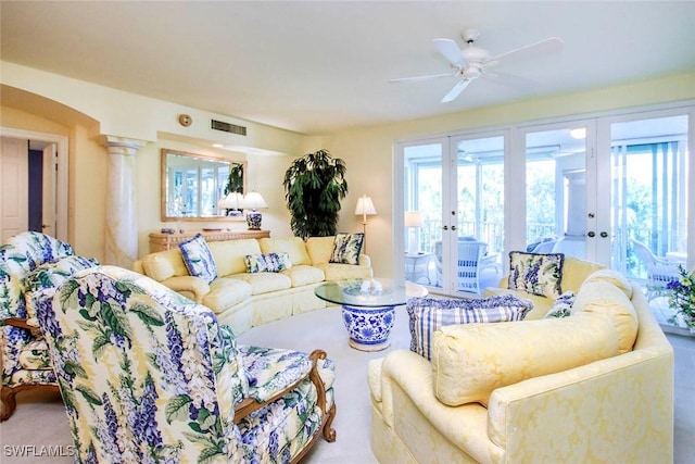 living room featuring ceiling fan, decorative columns, french doors, and a healthy amount of sunlight