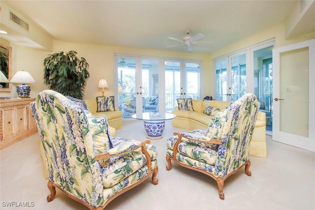 living room featuring light colored carpet, french doors, and ceiling fan