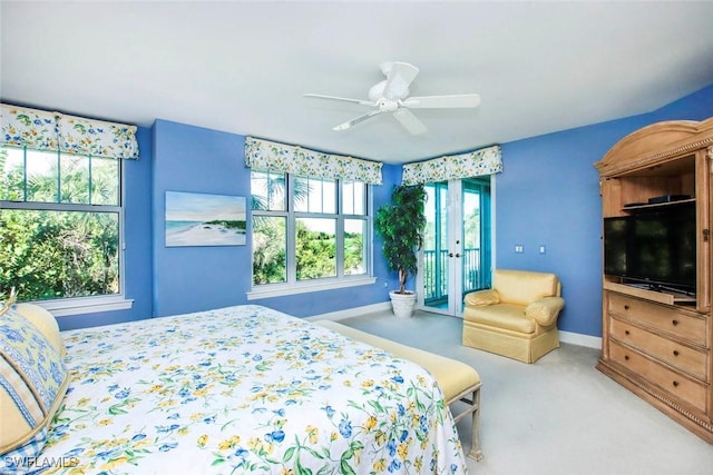 carpeted bedroom featuring french doors, ceiling fan, multiple windows, and access to outside