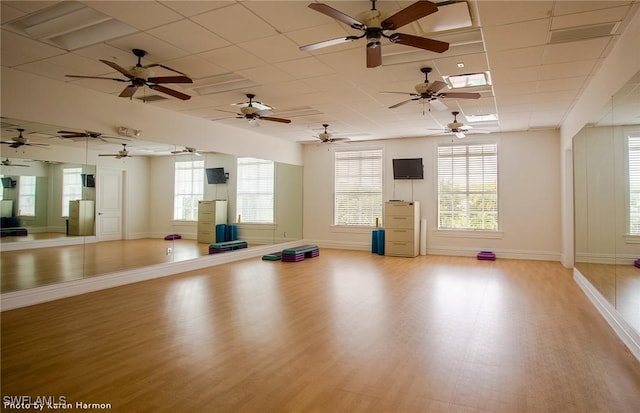 workout area featuring light hardwood / wood-style flooring and a paneled ceiling