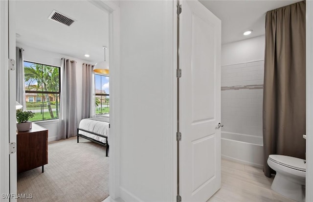 bathroom with toilet and bathing tub / shower combination