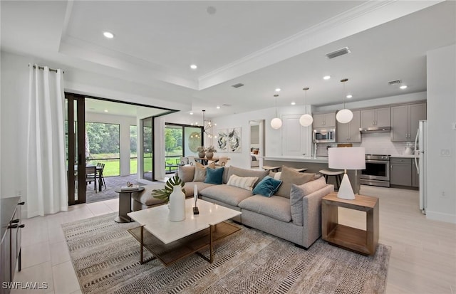 living room with a chandelier and a tray ceiling