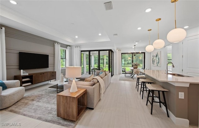 living room featuring sink and a tray ceiling